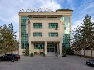 a building with a sign on top of it at Mountain View Residence Hotel in Almaty