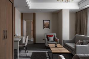 阿拉木图Mountain View Residence Hotel的客厅里有一张沙发和一张桌子。