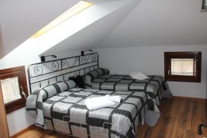 a bedroom with two beds in a attic at La Cantina del Tobero in Fuentetoba