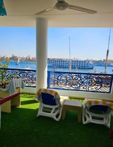 uma varanda com cadeiras e vista para a água em Villa Sunrise em Luxor
