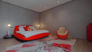 ein Schlafzimmer mit einem roten Bett und einem roten Stuhl in der Unterkunft Villa Syria Marrakech, Piscine Privée, Sauna et Gym in Marrakesch + 11 Fotos