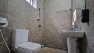 a bathroom with a toilet and a sink at Kilimanjaro Village Hotel in Mwika West