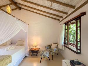 Pousada Hibisco في ترانكوسو: غرفة نوم بها سرير وكرسي وطاولة +151 صورة