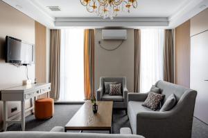 a living room with two chairs and a tv at Mountain View Residence Hotel in Almaty