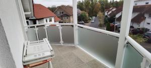 a chair on the balcony of a house at Ferienwohnung in Baunatal in Baunatal