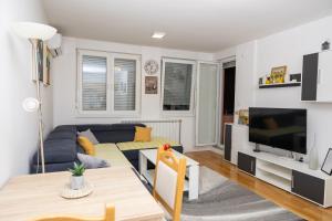 a living room with a couch and a tv at AVA Apartment Istočno Sarajevo in Lukavica