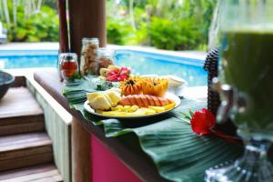 Pousada Hibisco في ترانكوسو: طبق من الطعام على طاولة بجوار حمام سباحة