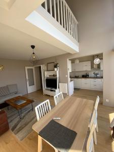 a dining room and living room with a table and chairs at Appartement moderne baigné de lumière en centre-ville in Douarnenez