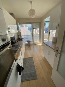 a kitchen with white cabinets and a black cat laying on the floor at Appartement moderne baigné de lumière en centre-ville in Douarnenez