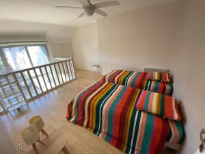 a bedroom with a bed with a colorful blanket at Appartement moderne baigné de lumière en centre-ville in Douarnenez