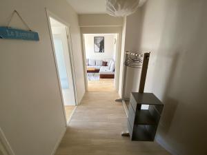 a hallway leading to a living room with a table at Appartement moderne baigné de lumière en centre-ville in Douarnenez +1 photo