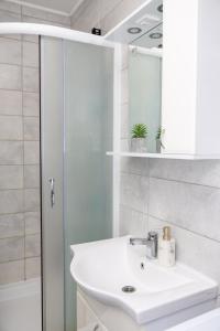 a white bathroom with a sink and a shower at AVA Apartment Istočno Sarajevo in Lukavica +20 photos