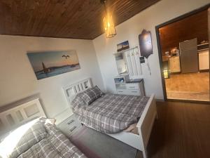 a small bedroom with two beds and a kitchen at Umm Aljulud Cottages 02 in Ajloun