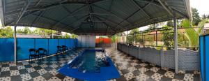 an indoor swimming pool with a large umbrella at UDUPI HOMESTAY - Sunrise Home in Udupi