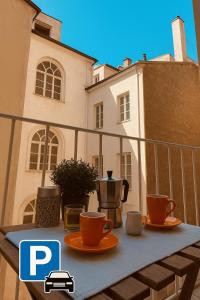 einen Tisch mit Tassen und Untertassen auf einem Balkon in der Unterkunft Residence Neverin Trieste in Triest