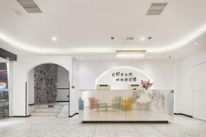 una grande stanza bianca con una vetrina con fiori di LIU YUAN Amoy Smart Hotel 厦门留苑智能酒店 a Xiamen