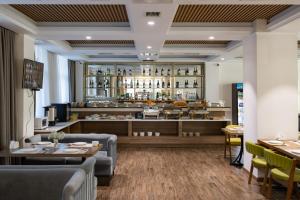 a restaurant with couches and tables and a counter at Mountain View Residence Hotel in Almaty