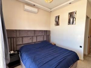 ein Schlafzimmer mit einem Bett mit einer blauen Decke in der Unterkunft Villa l'odyssée in Marrakesch