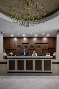 two men sitting at a reception desk in a hotel lobby at Mountain View Residence Hotel in Almaty