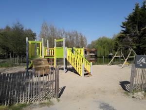 een speeltuin met gele en groene speeltoestellen in het zand bij Chalet bois 7 Domaine Les Epinettes in Saint-Gervais