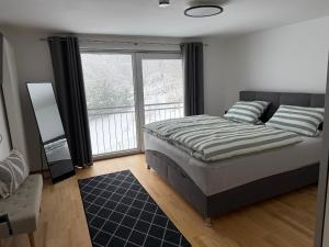 a bedroom with a bed and a large window at Landhaus am Burgberg in Freyung