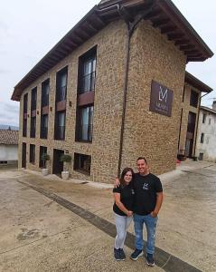 a man and woman standing in front of a building at Hotel Rural Milaleku in Ecala