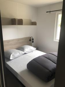 une chambre avec un lit et une fenêtre dans l'établissement Mobilehome Riviera avec terrasse 22, à Saint-Gervais