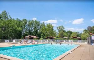 - une piscine dans un complexe avec des personnes dans l'eau dans l'établissement Mobilehome Riviera avec terrasse 22, à Saint-Gervais 11 autres photos