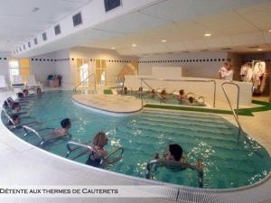 eine Gruppe von Menschen in einem Schwimmbad in der Unterkunft Chalet 2 chambres, 6 pers, terrasse, balcon, parking, wifi, près ski et commerces - FR-1-401-52 in Cauterets