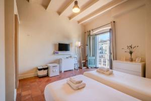 Un dormitorio con dos camas y una gran ventana. en Flateli Ballesteries, en Girona