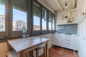 Una cocina con una mesa y algunas ventanas. en Flateli Ballesteries, en Girona