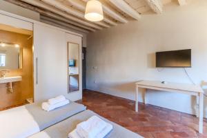 Una habitación con dos camas y un escritorio y un televisor. en Flateli Ballesteries, en Girona