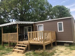 een tiny house met een veranda en een terras bij Mobilehome riviera avec terrasse 23 in Saint-Gervais