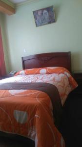 una camera da letto con un letto e un piumone arancione di Hotel Perla del Lago a Copacabana Altre 5 foto