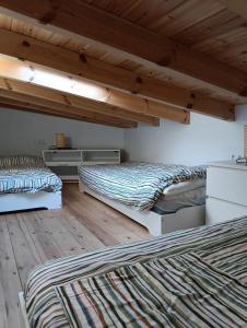 two beds in a room with wooden floors at Finca Las Abuelas in Galaroza