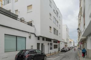 a black car parked on a street next to buildings at Casa En El Centro De Barbate in Barbate
