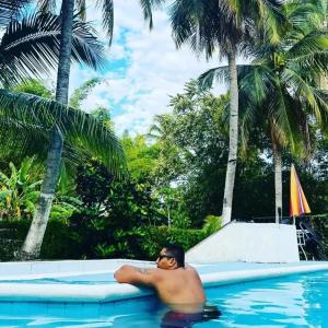 a man laying on a raft in a swimming pool at Siboney hotel in Honda