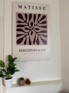 a picture on a wall above a shelf with a plant at 't Zusje in Enschede +1 photo