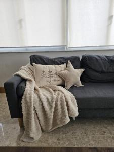 a blue couch with a blanket and pillows on it at Sea view Spacious 2 bedroom central apartment in Msida