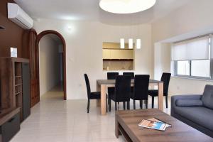 a living room and dining room with a table and chairs at Sea view Spacious 2 bedroom central apartment in Msida