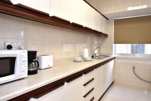 a kitchen with a microwave and a sink at Sea view Spacious 2 bedroom central apartment in Msida