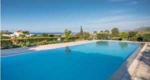 a large blue swimming pool with the ocean in the background at Amazing Sea View -3 Bed Ground Floor Garden Apartment in Kérynia