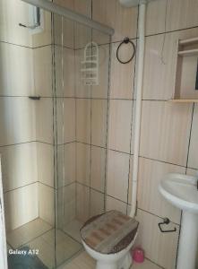 a bathroom with a shower with a toilet and a sink at Dúplex em Tramandaí in Tramandaí