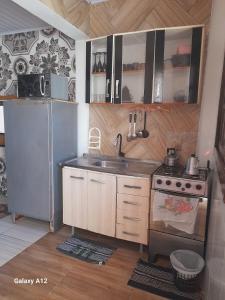 a kitchen with a sink and a refrigerator at Dúplex em Tramandaí in Tramandaí