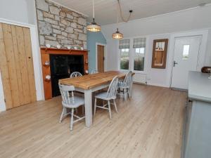 a kitchen and dining room with a wooden table and chairs at Braeburn in Bamburgh