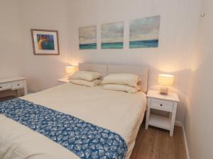 a small bedroom with a bed and two night stands at Braeburn in Bamburgh
