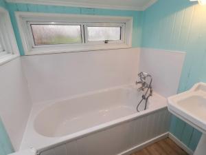 a bathroom with a tub and a sink and a window at Braeburn in Bamburgh +32 photos