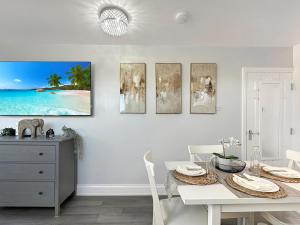 una sala da pranzo bianca con un tavolo e una cassettiera di Granada Apartments Holmfield Rd a Blackpool