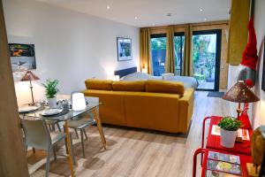 a living room with a yellow couch and a table at Le jardin de Séverine in Chalon-sur-Saône
