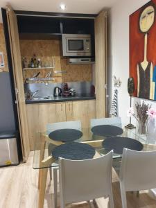 a dining room with a table and chairs and a kitchen at Le jardin de Séverine in Chalon-sur-Saône